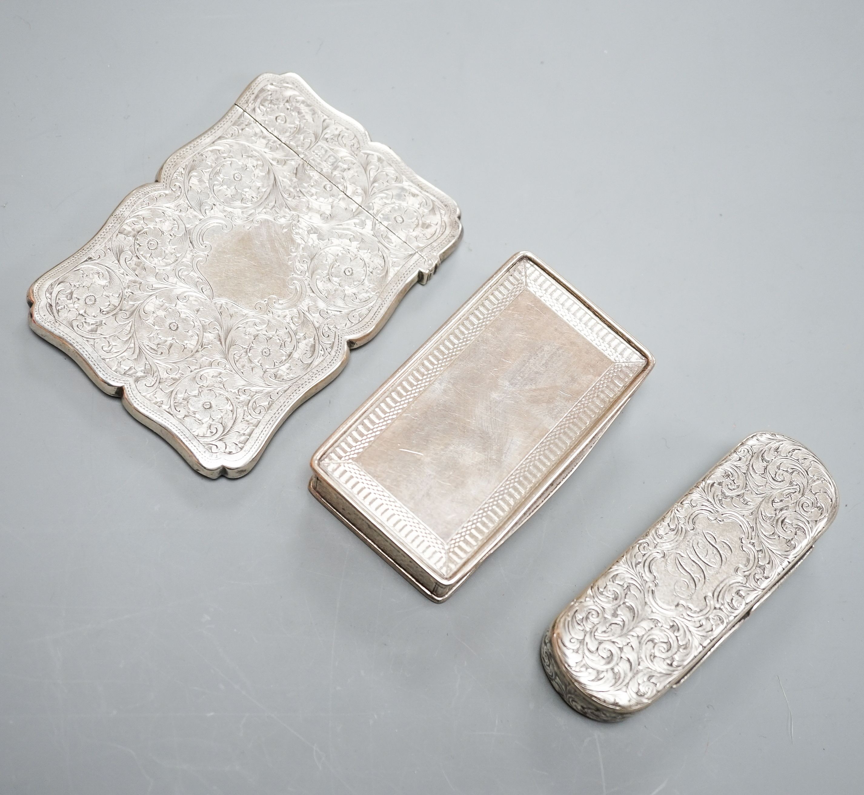 Two English silver snuff boxes, rectangular Birmingham, 1827, 81mm and Edward Smith oval, Birmingham, 1851 together with an Edwardian silver card case, Goldsmiths & Silversmiths, London, 1902.